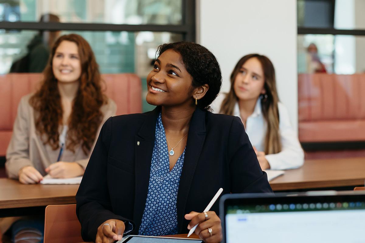 female students smiling and taking notes at Palm Beach Atlantic University